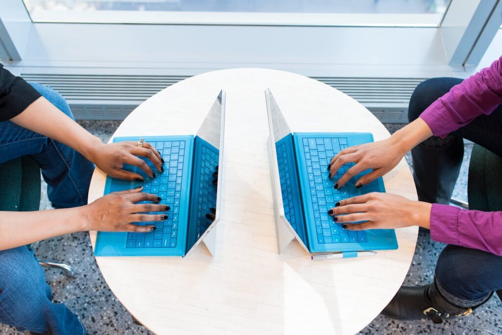 Two People Working on Laptops